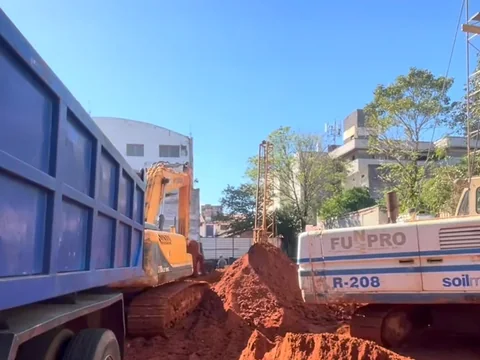 Volquete y excavadora en una excavación con retiro